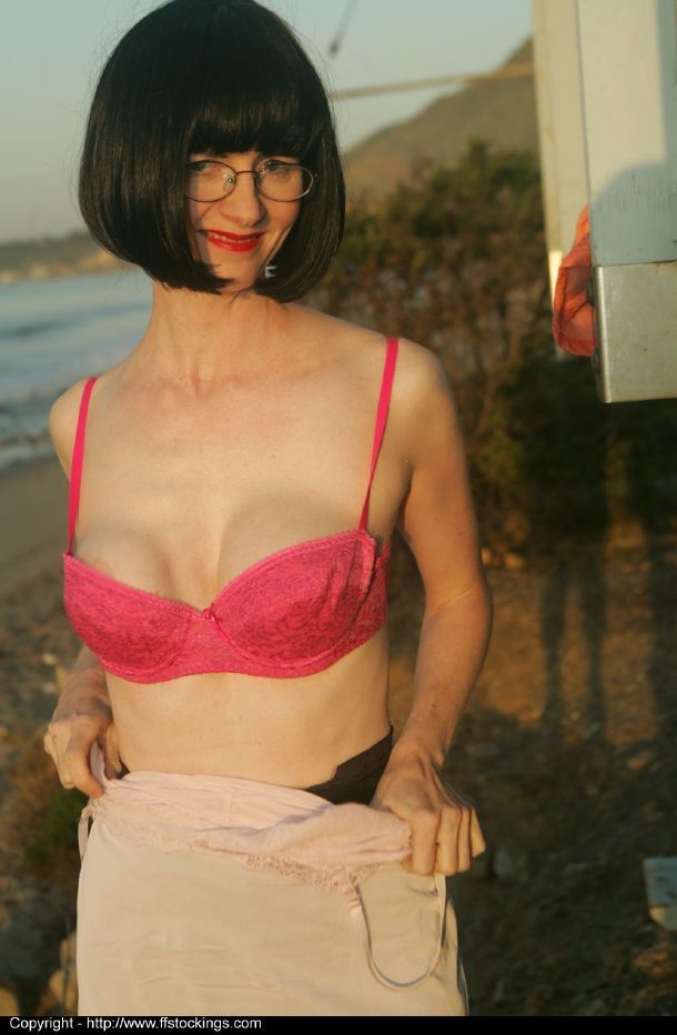 Brunette volwassen lady in Bril strippen uit haar kleding outdoor