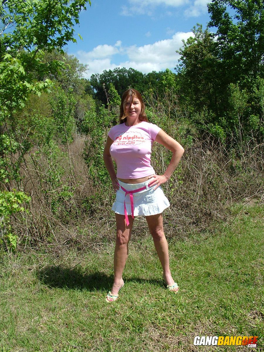 Mature woman Dee Delmar shows off her her large tits in backyard