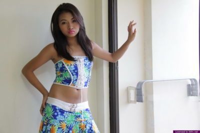 jóvenes Asiático Chica quita Ropa y blanco ropa interior en Frente de Un ventana