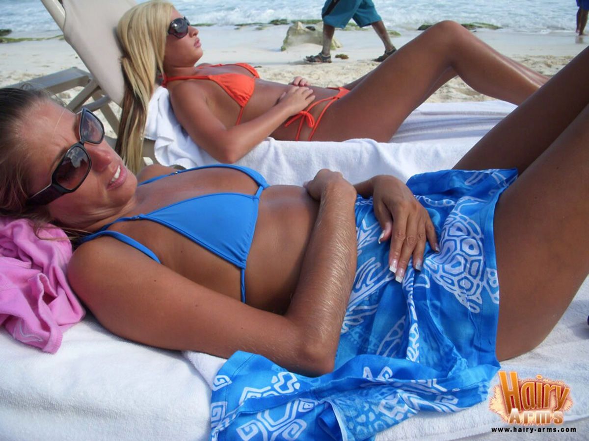 Hirsute blonde Lori Anderson relaxes on a beach in her bikini and sunglasses