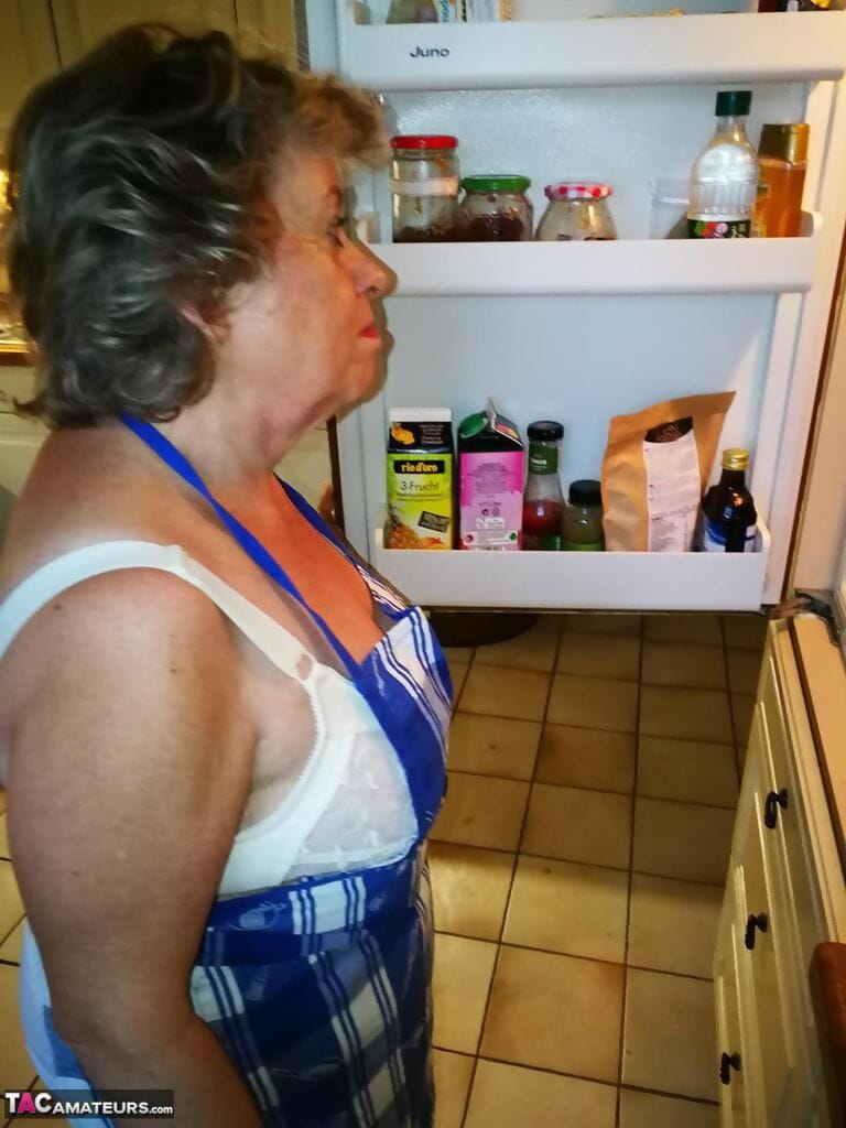 viejo ama de casa Caro toma off su ropa interior en cocina delantal y medias