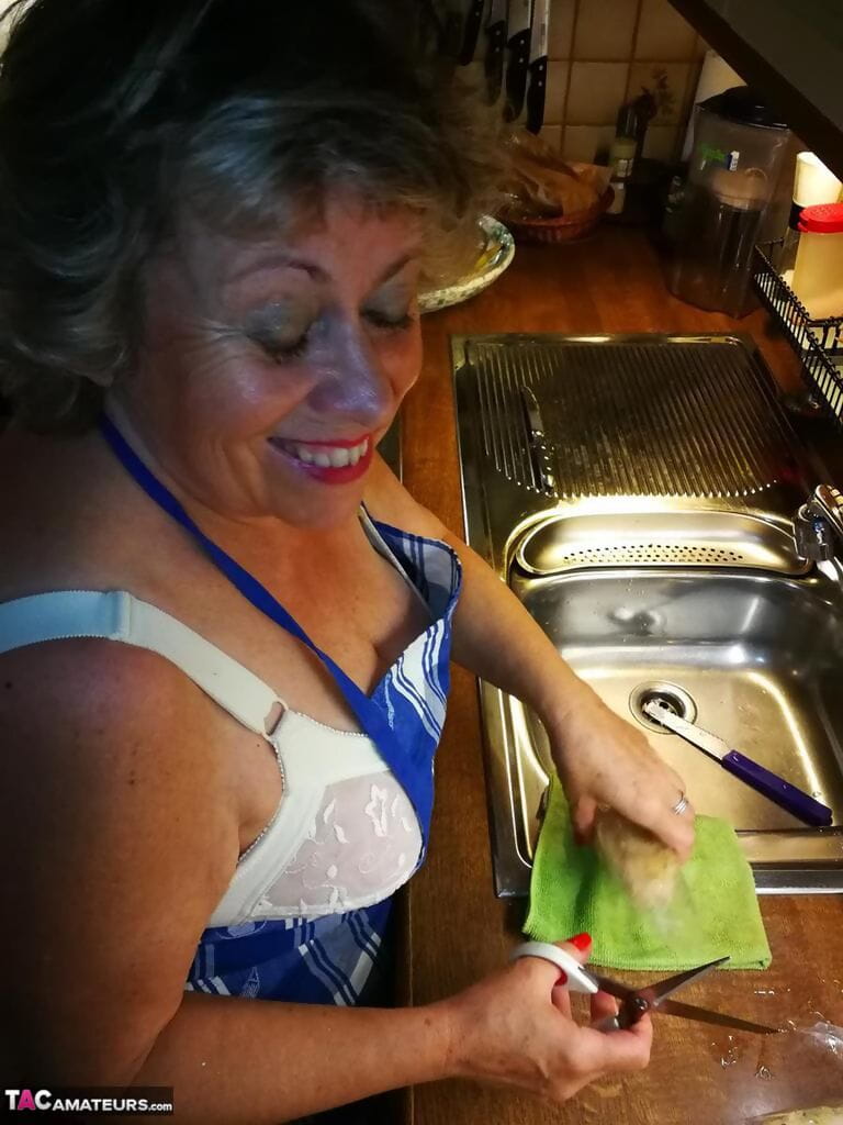 vecchio casalinga Caro prende off Il suo biancheria intima in cucina grembiule e calze