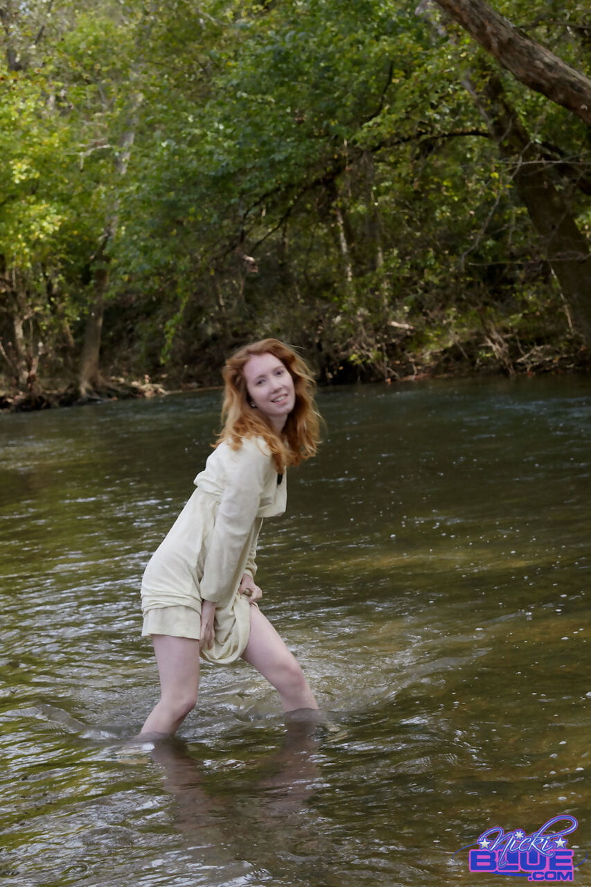 natural ruiva Nicki AZUL mostra alguns perna enquanto wading em um rasa stream