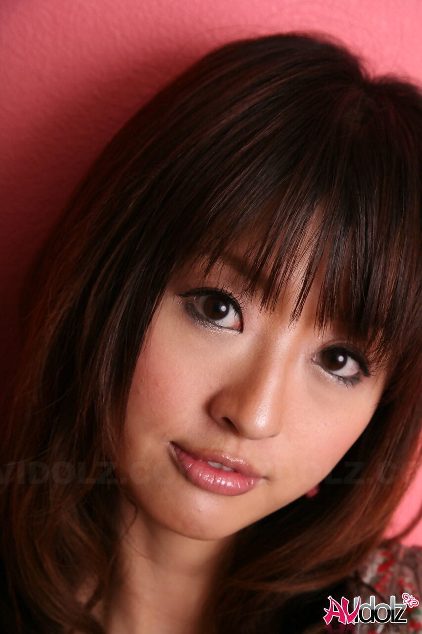 japonês modelo com um Muito rosto stands Vestido contra um Cor-de-rosa parede