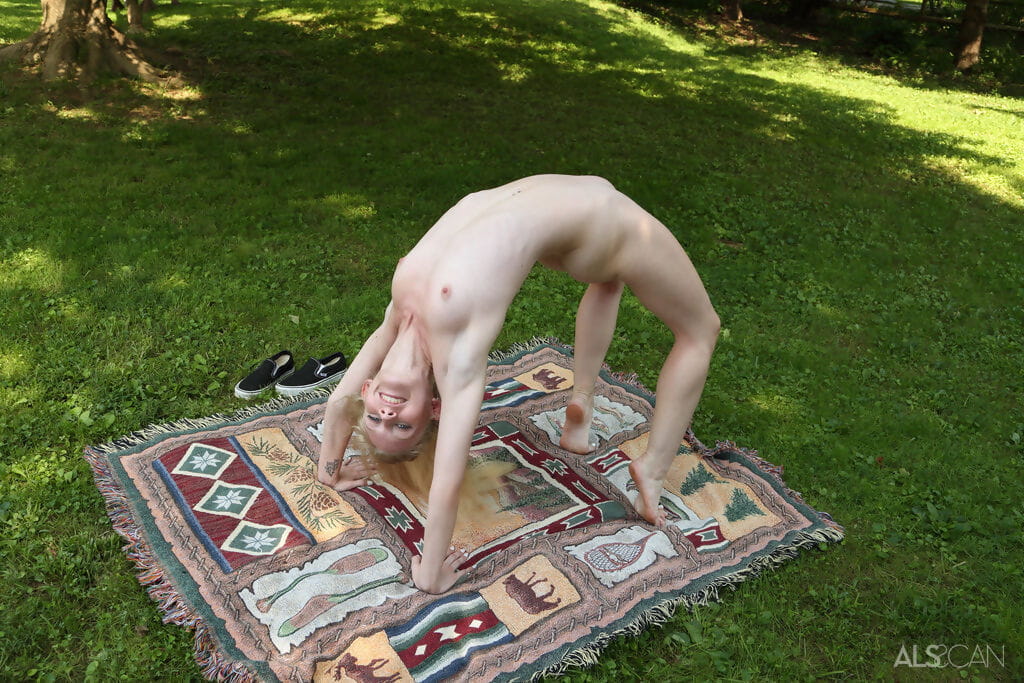 Cute blonde Emma Starletto shows off her flexibility while naked in the yard