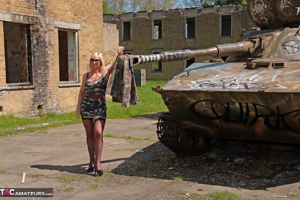 Blond chick Melodie verwijdert haar camouflage Jurk naar model lingerie op een tank