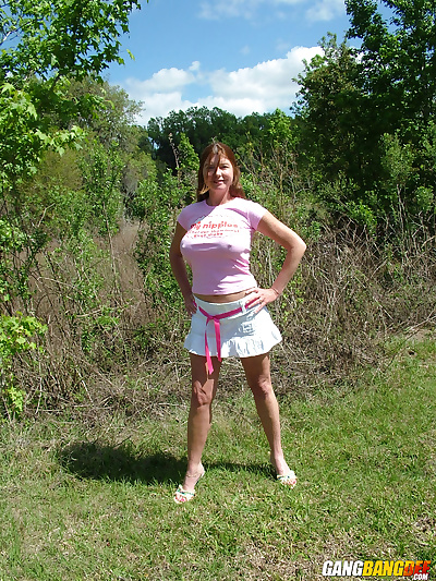Mature woman Dee Delmar shows off her her large tits in backyard
