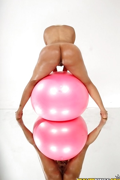 Oiled babe is masturbating her tight pussy while on a pink ball
